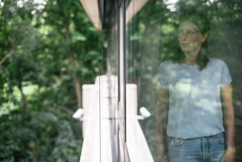 Frau schaut aus dem fenster in die natur